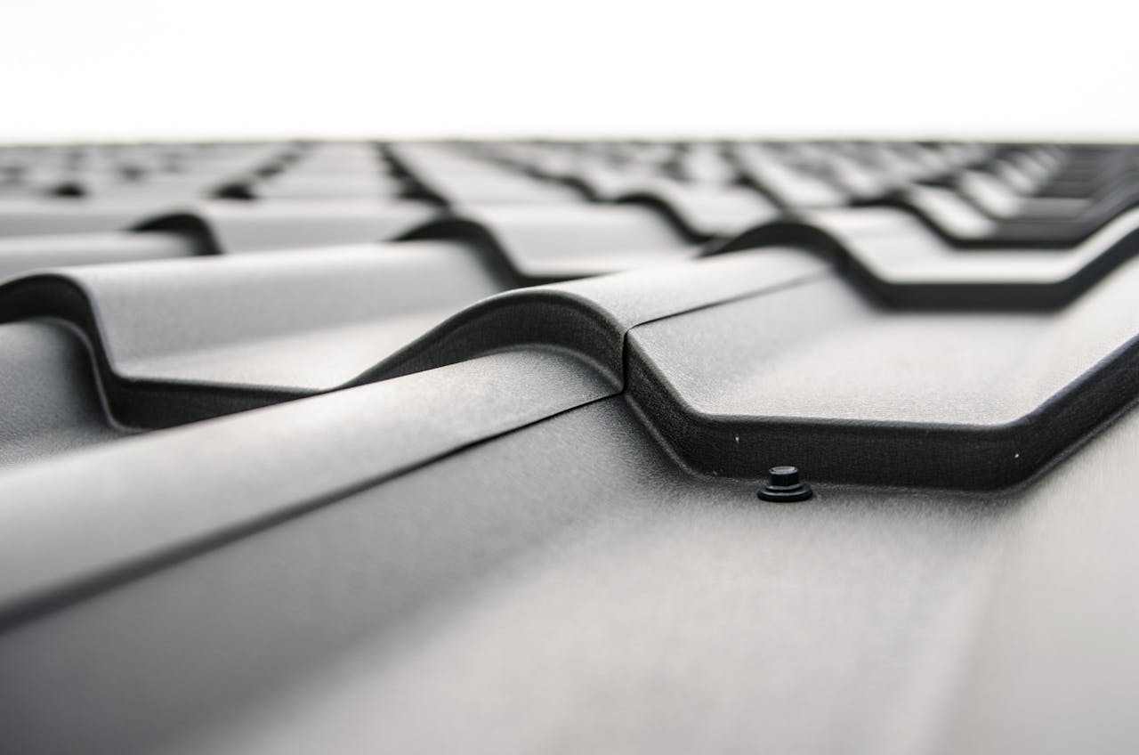 about-us Close-up view of a metal roof's wavy design showcasing rivets and structural detail.